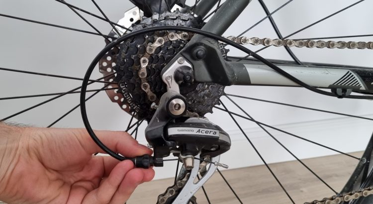 Hand making a rear derailleur adjustment